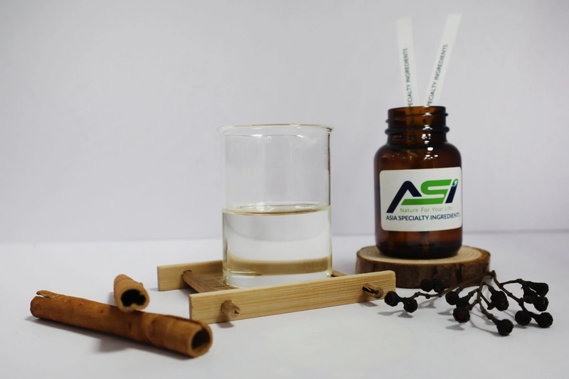 Lọ ASI, cốc tinh dầu và que khuếch tán đặt cạnh vỏ quế, sản phẩm của nhà cung cấp tinh dầu thiên nhiên