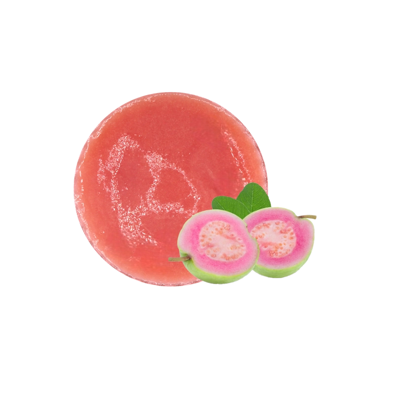 Puree ổi hồng màu hồng phấn bên cạnh hai nửa quả ổi ruột hồng còn vỏ xanh