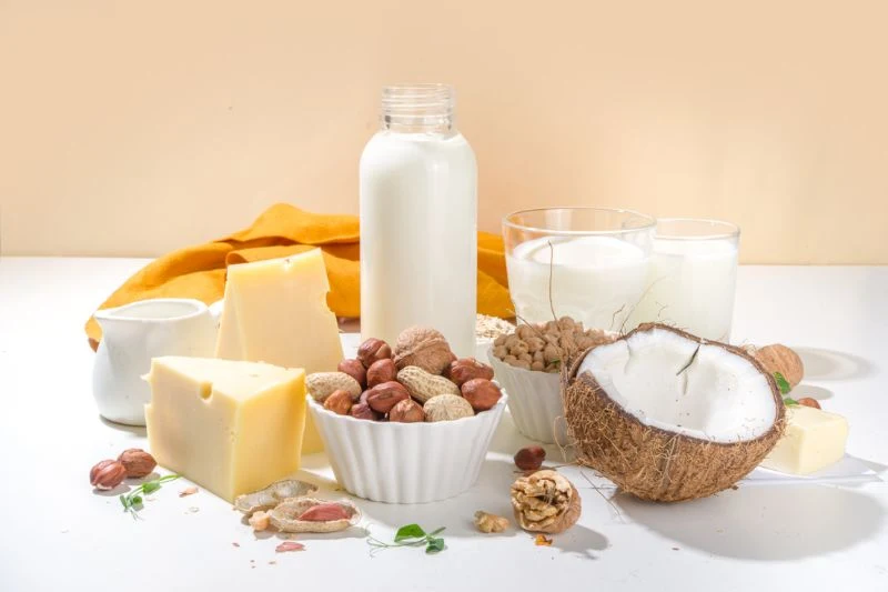 Bơ, phô mai, sữa tươi và các loại hạt bày trên bàn trắng, nhóm food ingredients cho ngành sữa