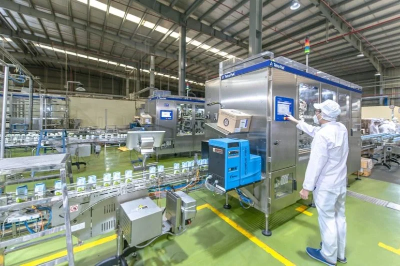 Công nhân vận hành máy đóng gói trên dây chuyền, khâu sản xuất trong giải pháp phát triển sản phẩm thực phẩm