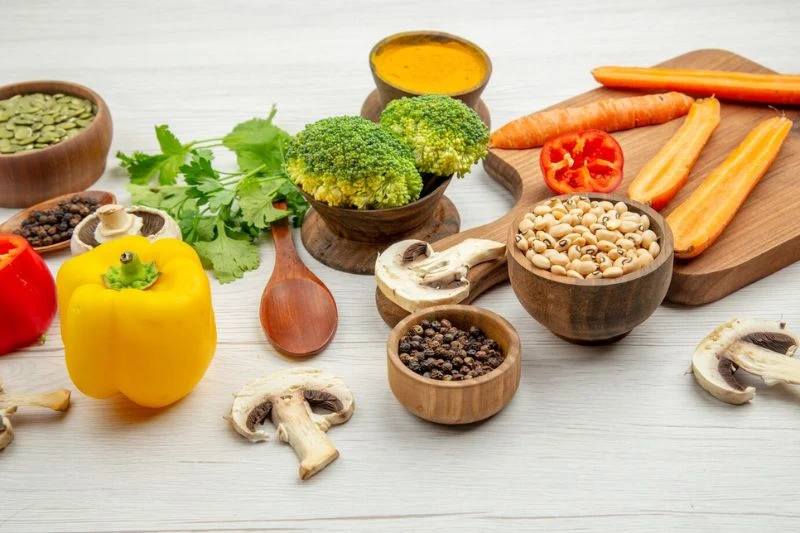 Rau củ, nấm, hạt bí và các loại đậu bày trên bàn gỗ trắng, nhóm nguyên liệu dinh dưỡng tự nhiên